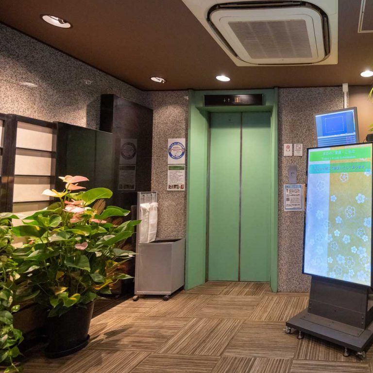 １階エントランス - エレベータ前に宴会ご案内パネルを設置しております